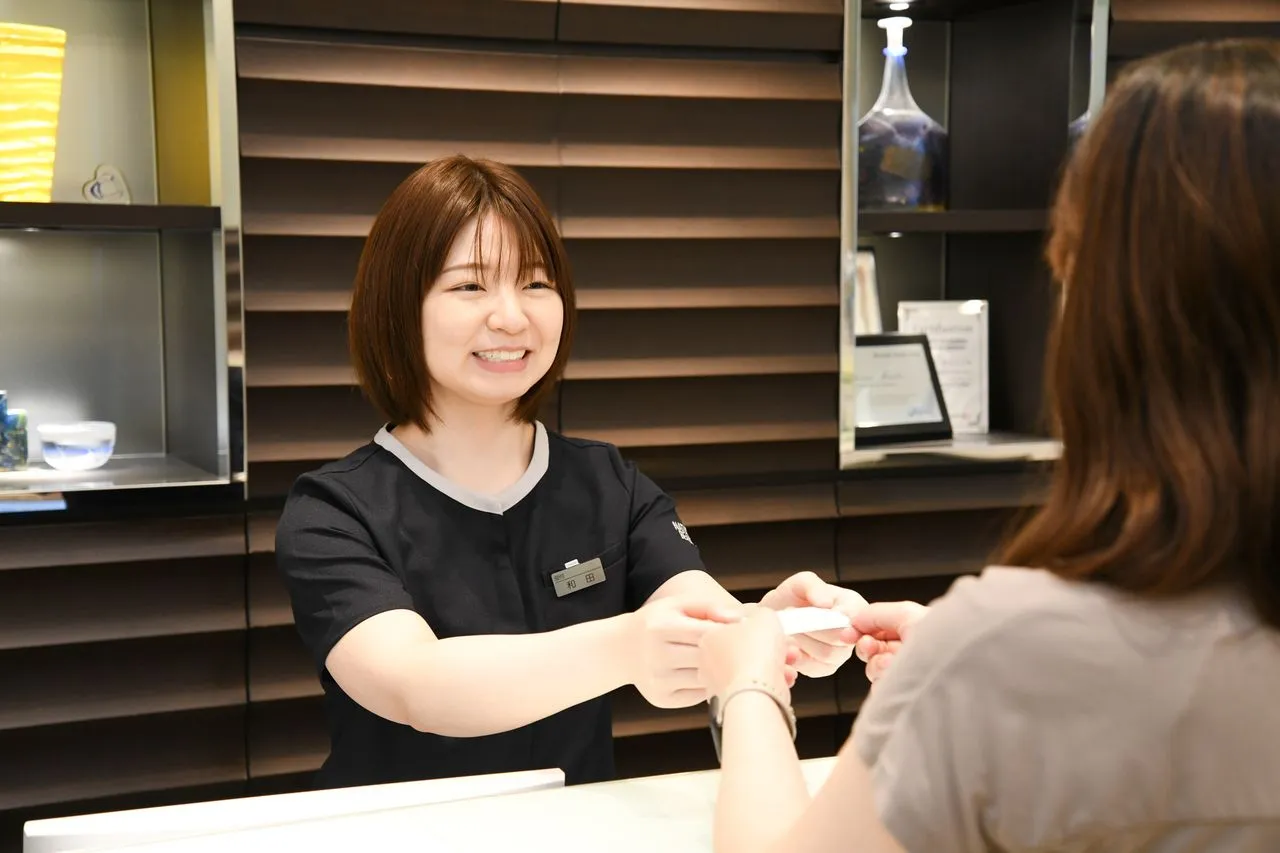 歯科医院の受付カウンターでスタッフが対応している様子