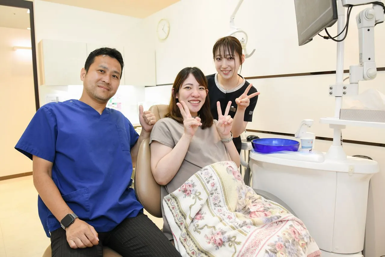 歯科医院の診療室で患者とスタッフが写っている様子