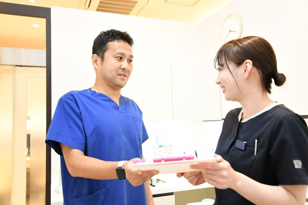 見つめ合う男性と女性の歯科医の写真