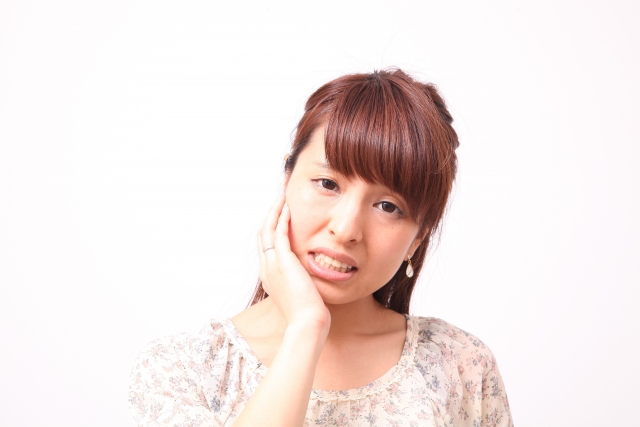 顎を抑える女性の写真